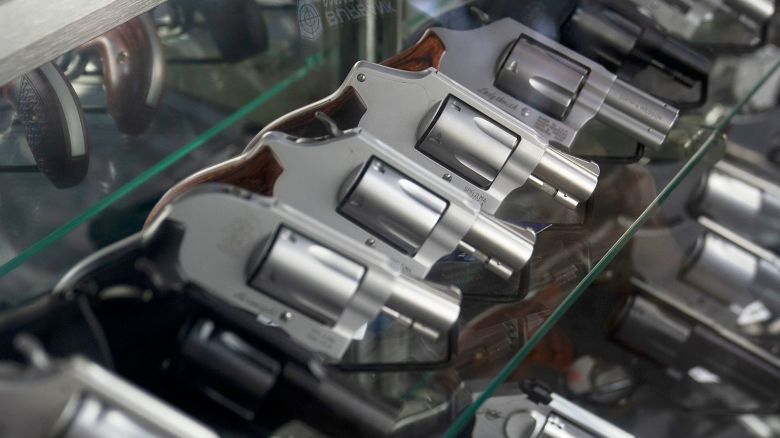 A sales associate arranges a display of guns at a firearms store in Burbank, California.